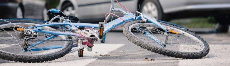 This image shows a bicycle on the ground after a collision with a car.