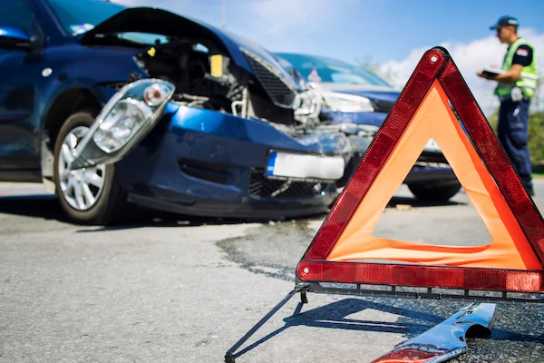 An officer writes a police report after a car accident.