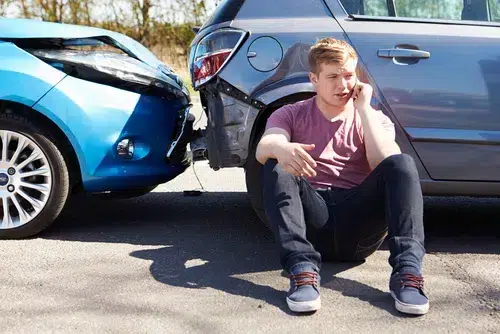 Driver sits outside of car after car accident talking to a car accident lawyer in Mableton, GA. 