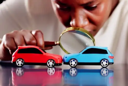 Accident Reconstruction Expert Investigates Car Crash With Magnifying glass