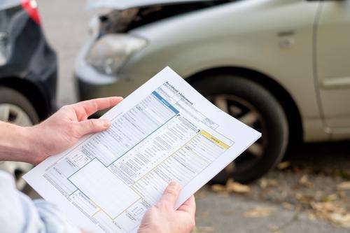 Insurance adjuster examining damaged car. Contact our Newnan reckless driving accident lawyers today. 