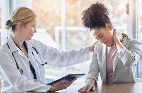 Car Accident Doctor Talking to Woman With Neck Pain