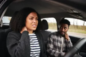Car Accident Passenger Claim Concept, Couple With Whiplash from Crash