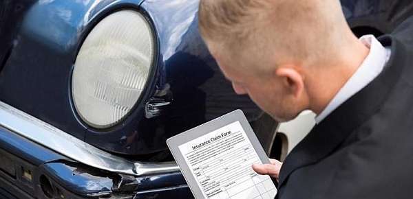 car insurance adjuster checking for damage