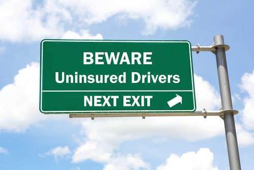 Road Sign With Beware of Uninsured Drivers Next Exit