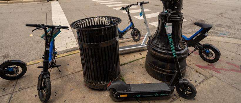 A group of rental scooters are negligently piled around a lightpost due to the many injuries acquired by scooter accident victims.
