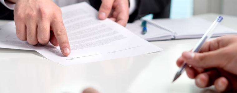 This image shows an Atlanta Uber accident lawyer presenting a client with a settlement agreement.