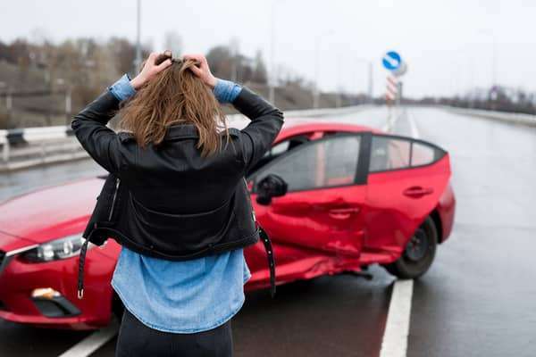 car accident woman stands near broken car