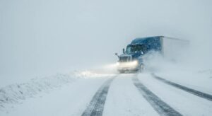 Semi-truck skidding on a snowy road during a snowstorm