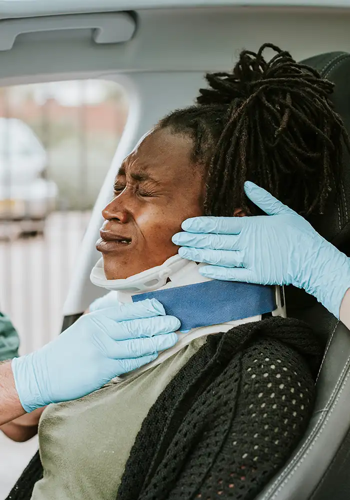paramedics putting a neck brace on a woman who is in a wreck car