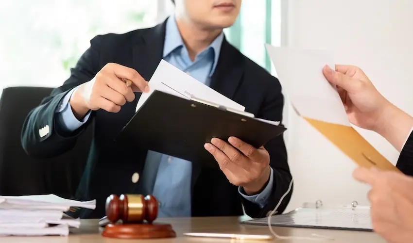 An attorney at The Weinstein Firm in Georgia is reviewing legal documents with a client regarding an airbag accident injury claim and compensation case.