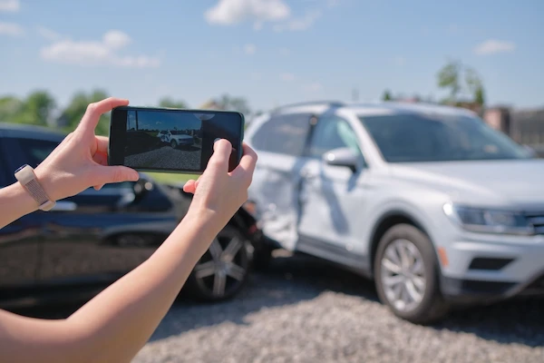 Driver taking photos after a car accident