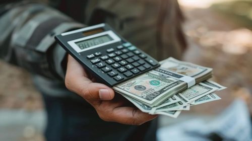 Image showing a hand holding money or a calculator, symbolizing financial compensation and the calculation of damages for victims